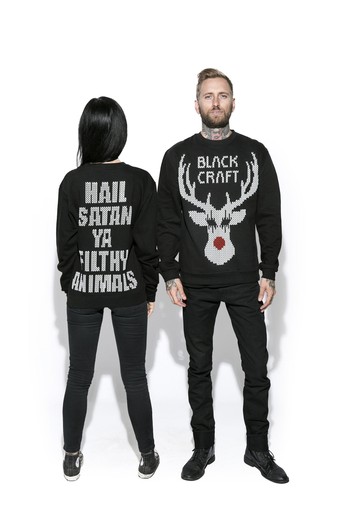 Two models wearing a black sweatshirt with the Blackcraft logo and a reindeer on the front and text on the back. 