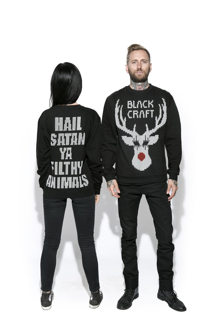 Two models wearing a black sweatshirt with the Blackcraft logo and a reindeer on the front and text on the back. 