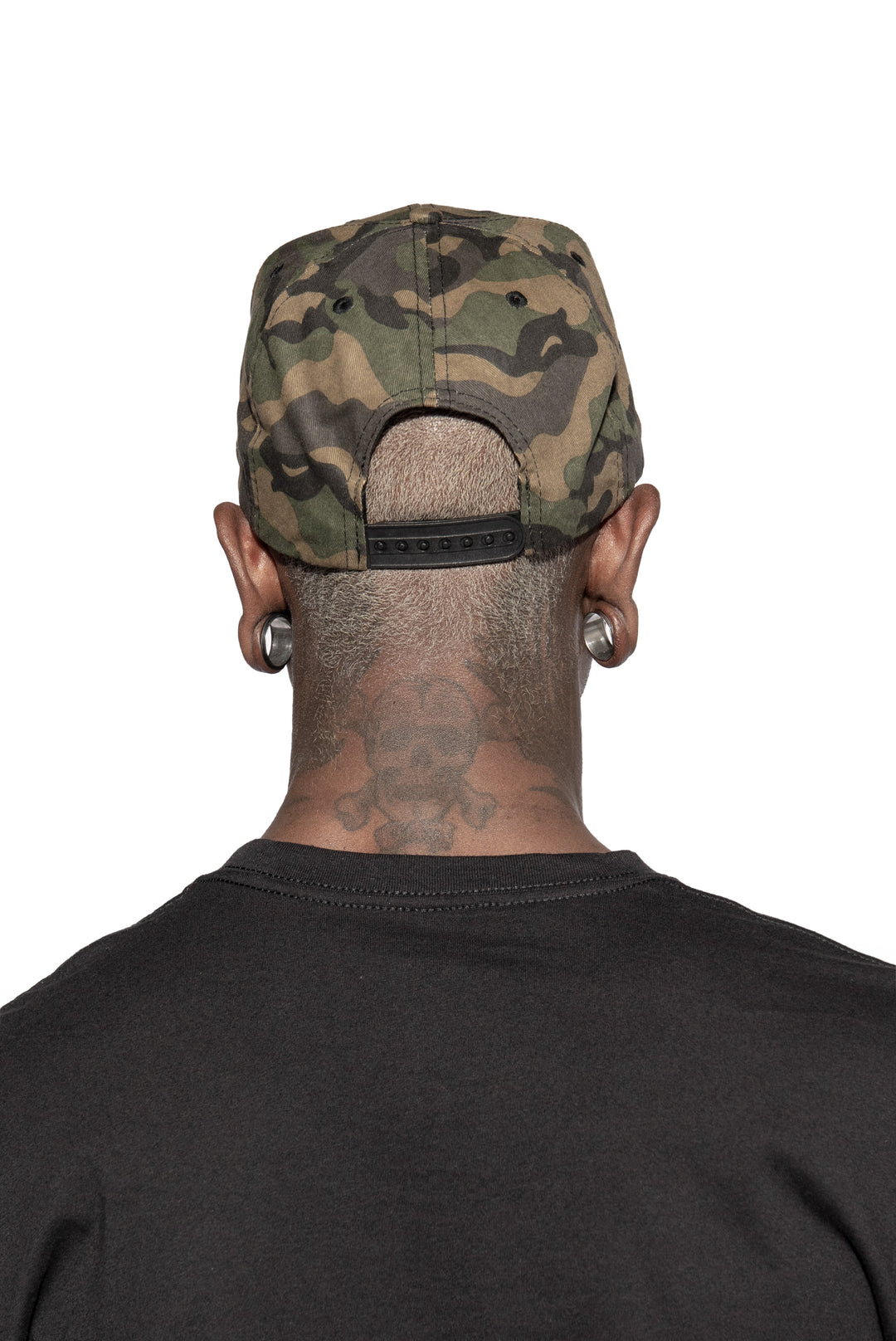 A model wearing a cotton snapback hat in a camo design, with an embroidered Blackcraft patch on the front.