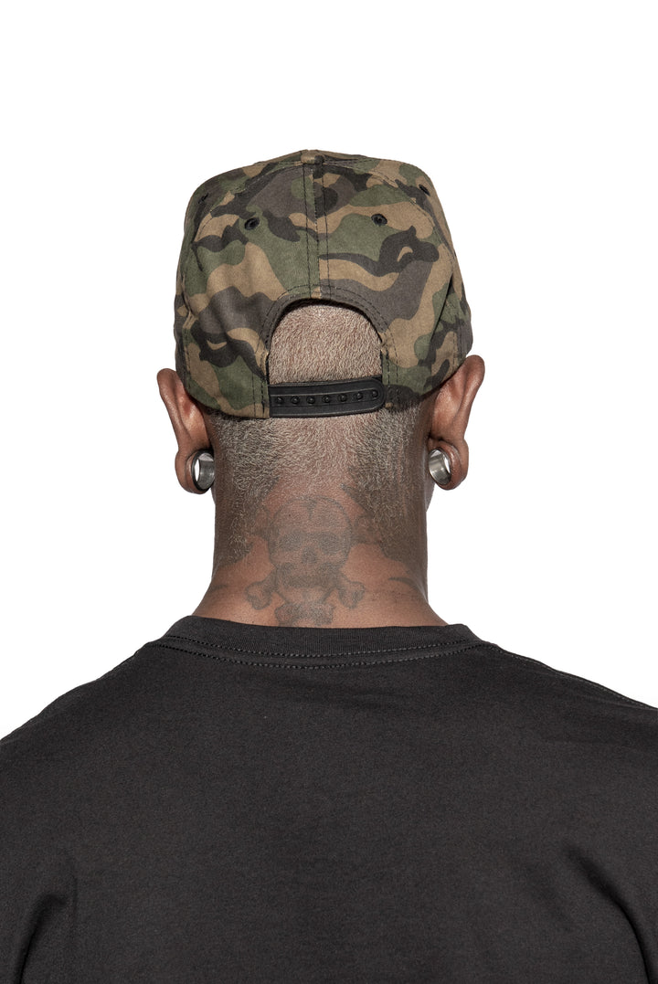 A model wearing a cotton snapback hat in a camo design, with an embroidered Blackcraft patch on the front.