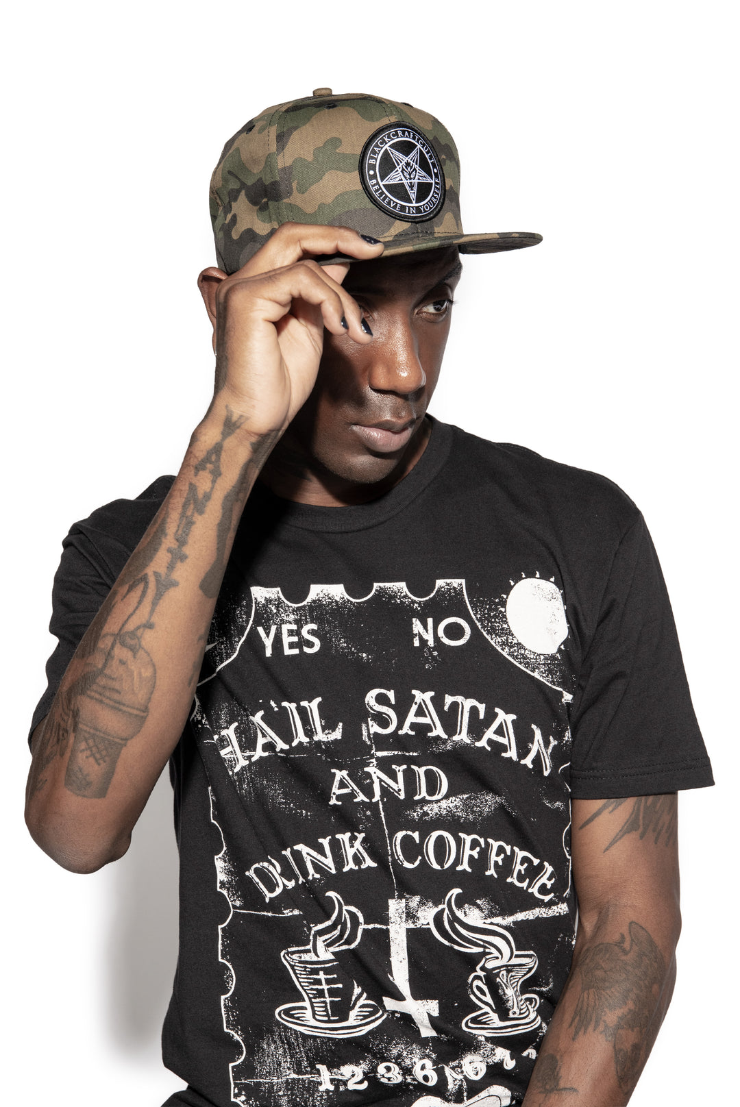 A model wearing a cotton snapback hat in a camo design, with an embroidered Blackcraft patch on the front.