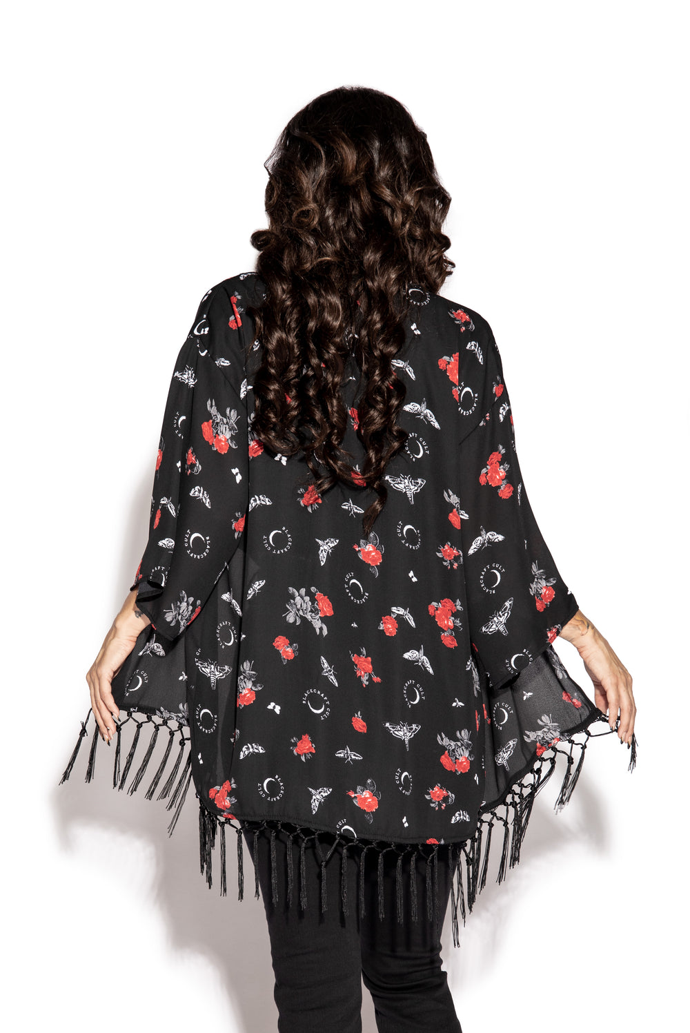 A gothic kimono cover up with fringed trim, and open front, and kimono half length sleeves.