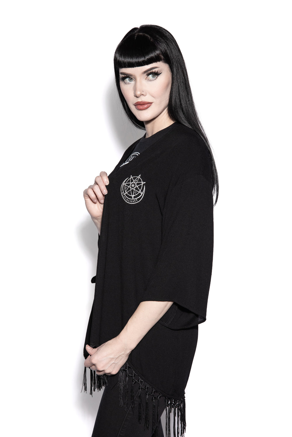 A gothic kimono cover up with fringed trim, and open front, and kimono half length sleeves.