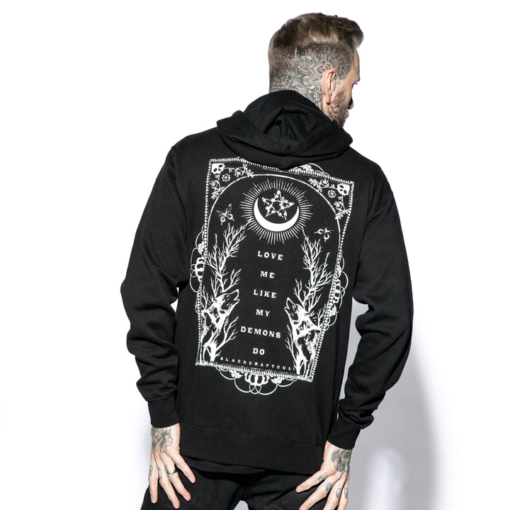 A male model wearing a classic black zip up hoodie with custom Blackcraft artwork on the front and back. 