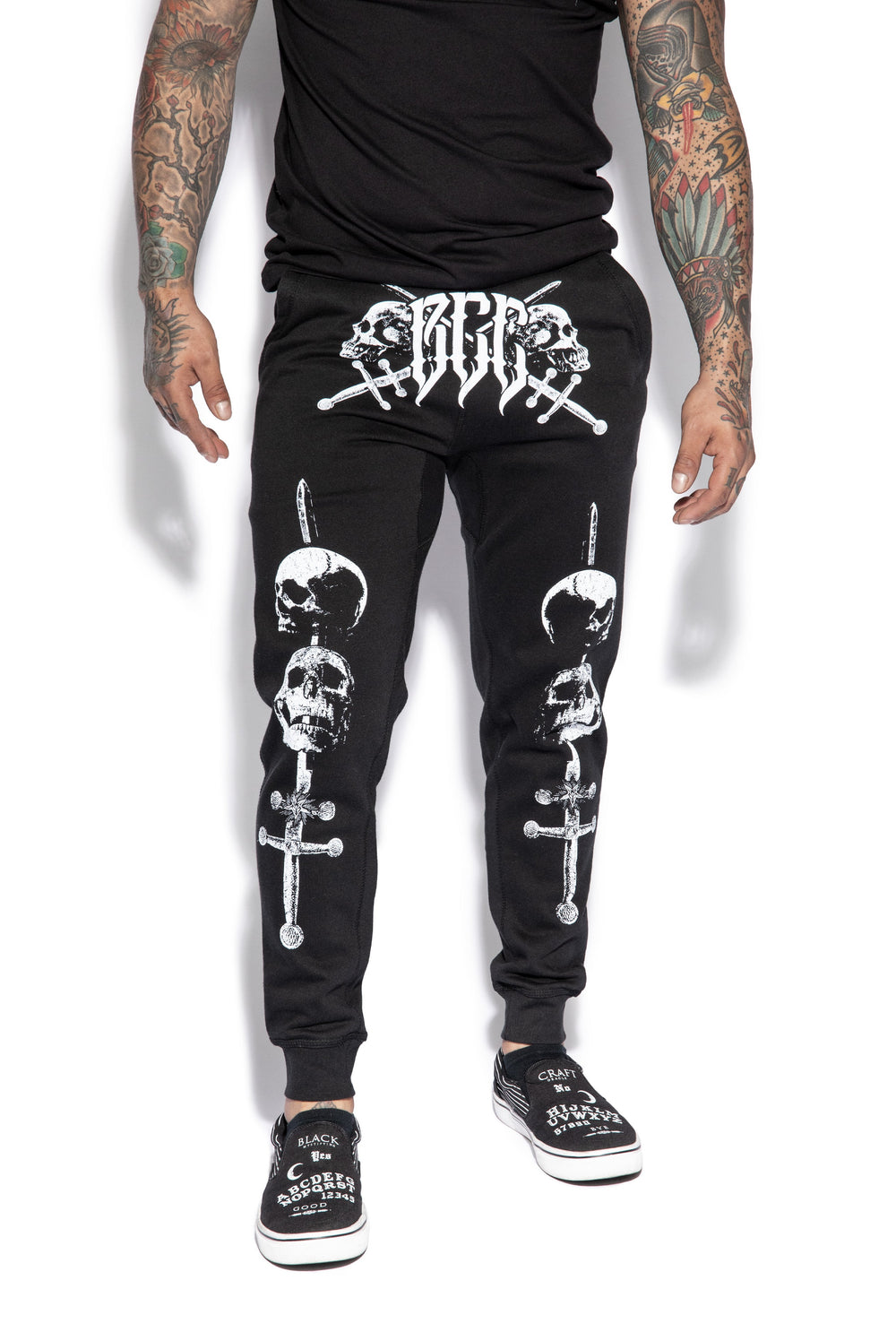 A model wearing a pair of classic fit black joggers with custom Blackcraft artwork along the front of each leg.