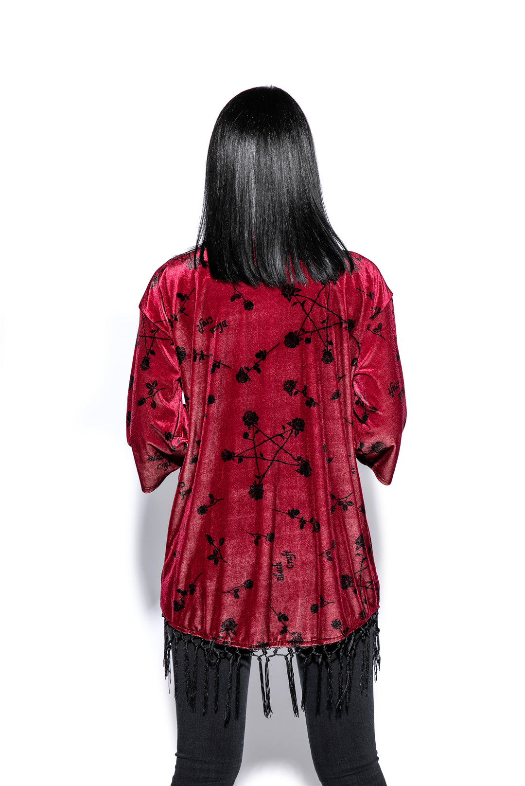 A gothic velvet kimono cover up with fringed trim, an open front, and kimono half length sleeves.