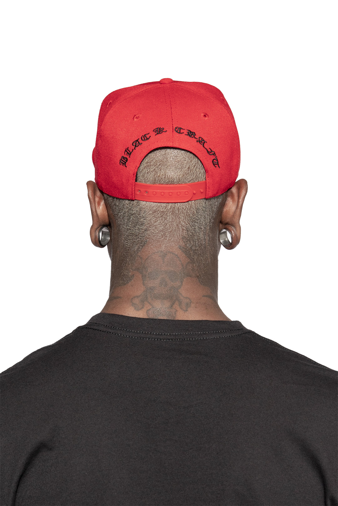 A classic red baseball cap with embroidered unholy across the front.