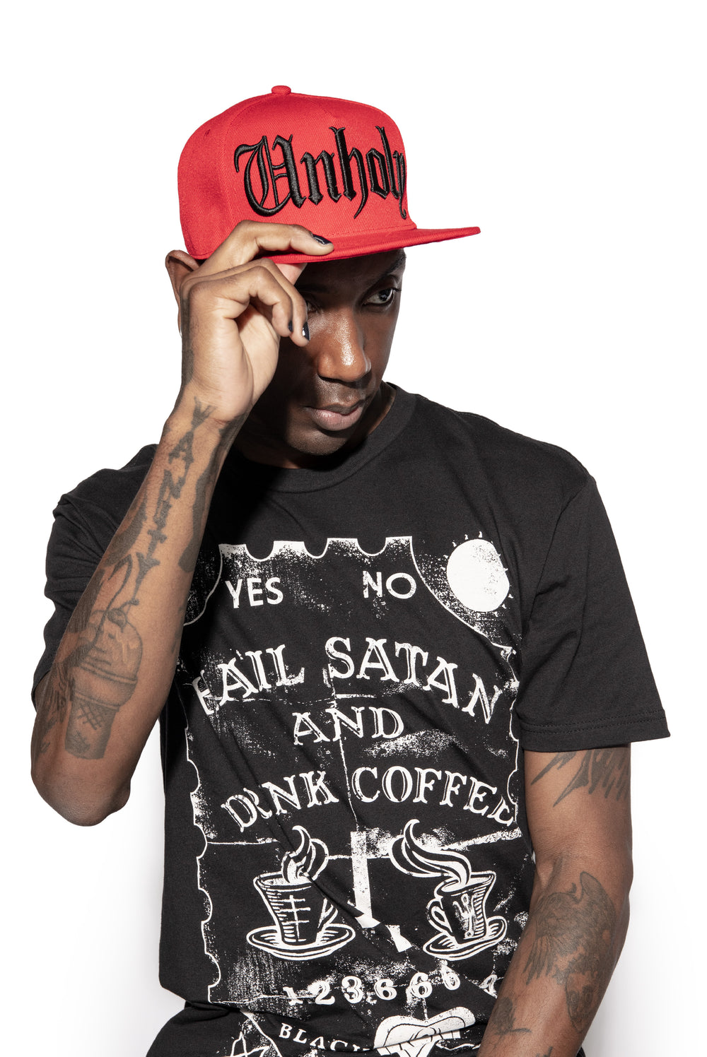A classic red baseball cap with embroidered unholy across the front.